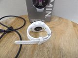 a smart watch sitting on a wooden table next to a box