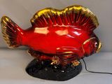 a red fish that is sitting on top of a black base