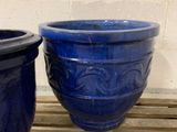 two blue planters sitting on a pallet next to each other