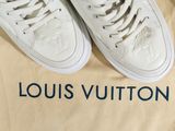 louis vuitton white leather sneakers with blue lettering on a beige background