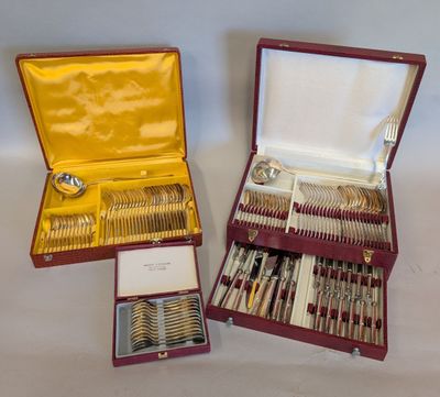 deux sets d'argenterie dans un coffret sur une table
