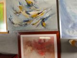 paintings on the wall above a desk with a laptop