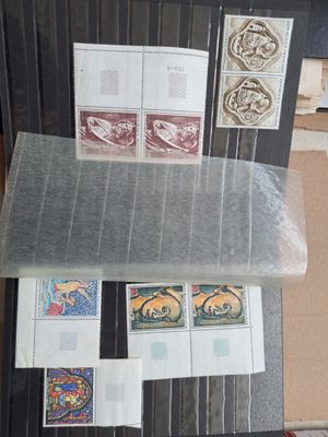 beaucoup de timbres posés sur une table recouverte de nombreux papiers