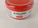 a jar of red paint sitting on a white table
