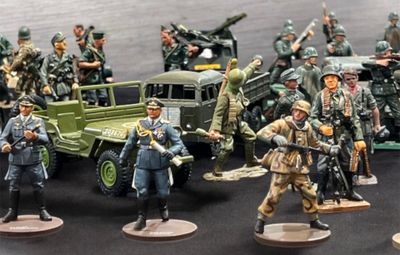 de nombreuses figurines représentant des militaires et des véhicules sur la table