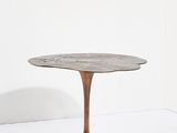 une table ronde avec un piètement en métal et un plateau en marbre