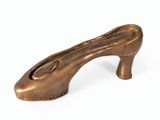 une image représentant un objet en bronze en forme de chaussure sur fond blanc