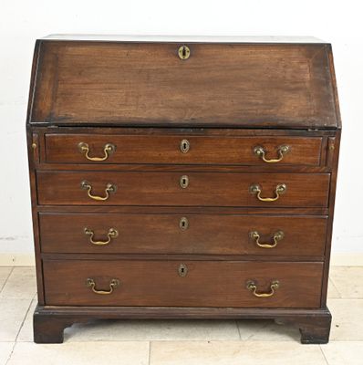 an antique wooden bureau with brass hardware on top of it