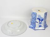 a blue and white vase and a white plate on a table