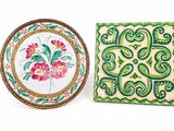 two decorative plates with designs on them are sitting next to each other