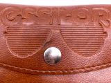 brown leather wallet with sunglasses on top of it on a white surface