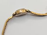an image of a gold watch on a white surface with a white background