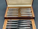 a set of six silver plated knives in a wooden case