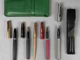 de nombreux stylos et un étui à stylos posés sur une table