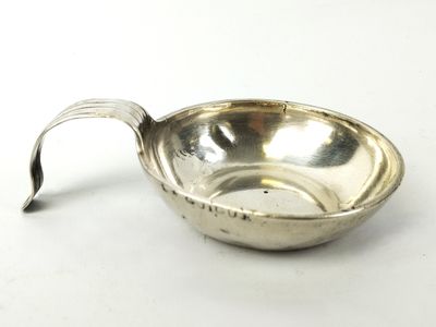 an antique silver plate with a handle on a white surface