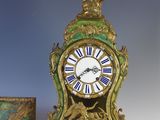 a green and gold clock sitting next to a box
