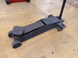 a black jack sitting on the floor in a garage