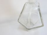 une bouteille en verre transparent avec un bouchon blanc posée sur une table
