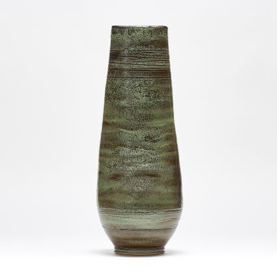 a green vase sitting on top of a white table