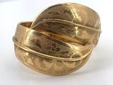 a close up of a gold ring on a white surface