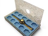 a box with a watch inside of it on a white surface