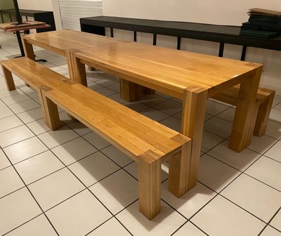 une table en bois avec deux bancs au milieu de la pièce
