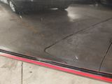 a black car parked in a garage with a red stripe