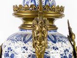 a blue and white vase with a gold handle on it