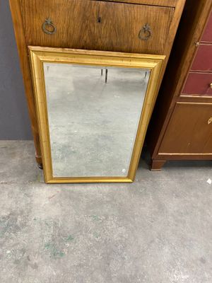 an image of a mirror sitting on top of a dresser next to a chest of drawers