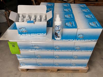 Plusieurs cartons d'eau sont empilés sur une palette dans un entrepôt