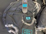 four pairs of winter boots with fur lined up on a black surface