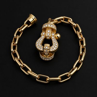 un gros plan sur un bracelet à chaîne en or orné d'une lettre « s »