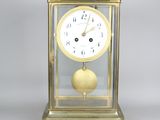 une horloge en or surmontée d'un couvercle en verre