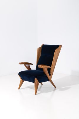 une image représentant une chaise avec une structure en bois et un revêtement en velours bleu