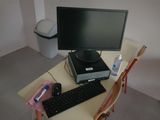 a desk with a computer, keyboard, mouse and other items on it