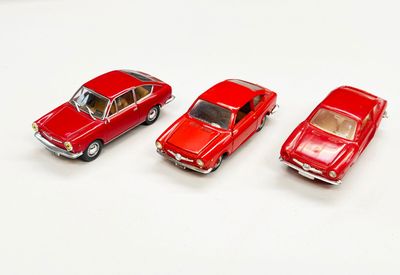 trois petites voitures rouges posées les unes à côté des autres sur une surface blanche