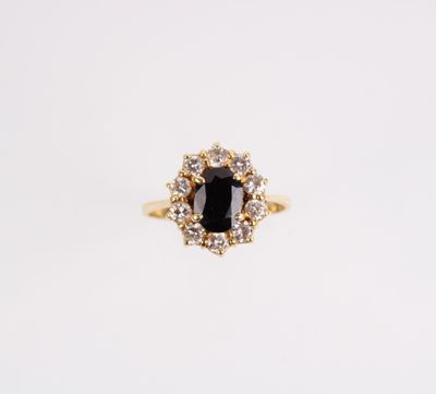 une bague en or sertie d'une pierre noire entourée de diamants blancs