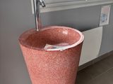un lavabo rose dans un coin de la salle de bains
