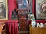 une horloge de parquet dans un coin d'une pièce rouge