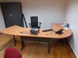 a desk with a laptop, phone, and other items on it