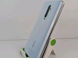 a close up of a cell phone on a stand on a white surface