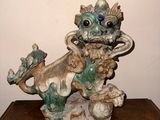 une statue représentant un dragon perché sur une caisse en bois