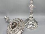a pair of silver candlesticks on a white background