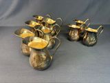 six silver plated pitchers with handles and handles on a grey background