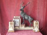 a statue of a stag on top of a clock on a table