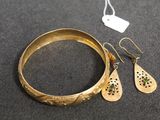 a close up of a bracelet and a pair of earrings on a table