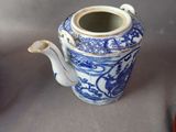 a blue and white teapot with a handle on a table