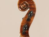 a close up of the back of a violin with a fiddle in the foreground