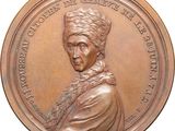une image d'une médaille de bronze représentant une femme portant un turban