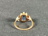 a close up of a gold ring with a blue stone